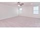 Large carpeted bedroom has a ceiling fan and two windows allowing ample natural light to fill the room at 111 Megby Trl, Statesville, NC 28677