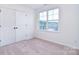 Bedroom featuring a large window, carpeted floors, closet, and a view of the neighbor's house at 111 Megby Trl, Statesville, NC 28677