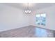 Open dining room features hardwood flooring, chandelier, and large windows at 111 Megby Trl, Statesville, NC 28677