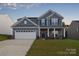 Charming two-story home with blue siding, white trim, and well-maintained landscaping at 111 Megby Trl, Statesville, NC 28677
