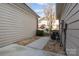 View of gravel side yard between homes with an AC Unit at 1127 Central Park Cir, Davidson, NC 28036