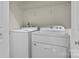 Bright laundry area with a washer, a dryer, and wire shelving for storage at 1127 Central Park Cir, Davidson, NC 28036