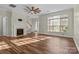 Bright living room features a fireplace, ceiling fan, and large windows with wood floor at 1127 Central Park Cir, Davidson, NC 28036