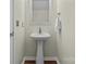 This cozy powder room features a pedestal sink, square mirror, and wood-look floors at 1127 Central Park Cir, Davidson, NC 28036