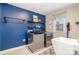 Laundry room with blue walls, floating shelves, and stainless steel washer and dryer at 114 Tomahawk Dr, Mooresville, NC 28117