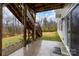 Concrete patio under an elevated deck featuring a well-maintained lawn and access to the backyard at 114 Tomahawk Dr, Mooresville, NC 28117