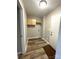 Well-lit laundry room with wood flooring, storage cabinets and shelving, and a white utility door at 1141 Faile St, Lancaster, SC 29720