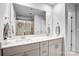 A well-lit bathroom featuring a double vanity, large mirror, and glass-enclosed shower, offering a spa-like experience at 12224 Diablo St, Huntersville, NC 28078