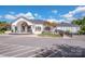 Front view of the bright white clubhouse featuring a covered entrance, arched windows, and meticulous landscaping at 140 Jana Dr, Statesville, NC 28677