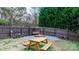 Fenced backyard features a wood picnic table, fire pit, swing, and plenty of mature trees at 1818 Valley Springs Se Dr, Conover, NC 28613