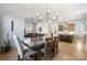 Open-concept dining room that flows into the living room and kitchen featuring a modern chandelier at 297 Greenwood Ave, Belmont, NC 28012