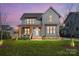 Charming two-story home with covered front porch, natural wood elements, and manicured lawn at 297 Greenwood Ave, Belmont, NC 28012