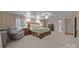 Cozy bedroom with a king-size bed, an elegant chair, and sconce lighting at 305 Wagner St, Troutman, NC 28166