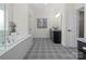 Bright bathroom featuring a soaking tub, black and white patterned tile floors, and a modern vanity at 3078 Montreaux Valley Dr, Fort Mill, SC 29707