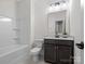 Modern bathroom with a white tub/shower combo, dark vanity and neutral accents at 3078 Montreaux Valley Dr, Fort Mill, SC 29707