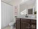 Well-lit bathroom featuring a shower with white curtain, vanity with dark hardware, and decor at 3078 Montreaux Valley Dr, Fort Mill, SC 29707