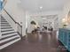 Open-concept living area with a fireplace, hardwood floors, and a staircase at 3078 Montreaux Valley Dr, Fort Mill, SC 29707