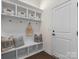 Organized mudroom with white bench, storage cubbies, decorative pillows, and coat hooks near the entry door at 3078 Montreaux Valley Dr, Fort Mill, SC 29707