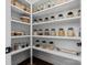 Well-organized pantry featuring shelving with glass jars, wicker baskets, and dark hardwood flooring at 3078 Montreaux Valley Dr, Fort Mill, SC 29707