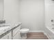 Bright bathroom featuring a granite vanity, white fixtures, and wood-look flooring at 3267 Maple Ridge Dr, Gastonia, NC 28052