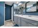 A modern bathroom with double sinks, gray cabinets, framed mirrors, and blue accent wall at 3427 Laurel Oak Ln, Gastonia, NC 28056