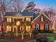 Elegant brick home with manicured lawn and landscape lighting at dusk at 3711 Cheleys Ridge Ln, Charlotte, NC 28270