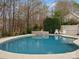 Backyard pool with clear water surrounded by lush landscaping and outdoor seating at 3711 Cheleys Ridge Ln, Charlotte, NC 28270