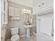 Well-lit bathroom featuring a pedestal sink, glass shower, and storage cabinets at 4132 Sulkirk Rd, Charlotte, NC 28210