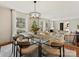 Dining area featuring a glass-top table, modern lighting fixture, and an open view to the living room at 4132 Sulkirk Rd, Charlotte, NC 28210