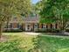 Charming brick home with a well-manicured lawn and lush landscaping surrounding the front entrance at 4132 Sulkirk Rd, Charlotte, NC 28210