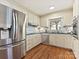 Well-lit kitchen featuring stainless steel appliances, white cabinetry, and hardwood floors at 4132 Sulkirk Rd, Charlotte, NC 28210