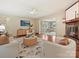 Cozy living room featuring a brick fireplace, hardwood floors, and an open view to an office at 4132 Sulkirk Rd, Charlotte, NC 28210