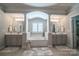 Elegant bathroom showcasing dual vanities, a large soaking tub with natural light, and neutral tile flooring at 4268 Rustling Woods Dr, Denver, NC 28037