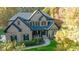 Charming brick two story home with black shutters, manicured lawn, and walkway leading to the front door at 4268 Rustling Woods Dr, Denver, NC 28037