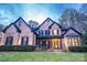 Stunning brick home with a well-manicured lawn, black shutters, and a charming front entrance with a wreath at 4268 Rustling Woods Dr, Denver, NC 28037