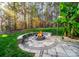Outdoor fire pit with stone surround and patio in a wooded backyard setting, perfect for outdoor gatherings at 4268 Rustling Woods Dr, Denver, NC 28037