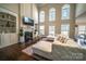 Inviting living room with a fireplace, built-in bookshelves, hardwood floors, and lots of natural light at 4268 Rustling Woods Dr, Denver, NC 28037