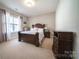 Main bedroom with carpeted floors, a window with curtains, and dark wood furniture at 4268 Rustling Woods Dr, Denver, NC 28037