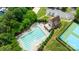 Aerial view of pool and clubhouse, surrounded by trees, sand volleyball court, and parking at 4268 Rustling Woods Dr, Denver, NC 28037