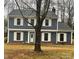 Traditional home featuring neutral siding, white trim, and a prominent tree in the front yard at 4922 Rivergreen Ln, Charlotte, NC 28227