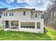 Two-story home with a covered outdoor seating area and upper level balcony overlooking the lush green lawn at 5026 Ohm Ln, Charlotte, NC 28270