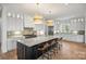 Open kitchen with large island, stainless appliances, white cabinets, and hardwood floors at 5026 Ohm Ln, Charlotte, NC 28270
