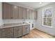 Modern laundry room has custom cabinets, quartz countertop, sink, window and hardwood floors at 5026 Ohm Ln, Charlotte, NC 28270