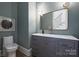 Modern half bathroom with marble countertop, gray vanity, and stylish lighting at 5026 Ohm Ln, Charlotte, NC 28270