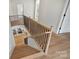 Elegant wooden staircase with black metal railing, leading to the main level at 5026 Ohm Ln, Charlotte, NC 28270