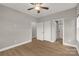 Neutral bedroom featuring wood-look floors, ceiling fan, closet, and en-suite bathroom at 5051 Oxbow Run Ln, York, SC 29710