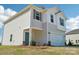 This new construction features a teal entry door, two-car garage, manicured flower beds and a light-colored exterior at 5207 Georgette Trl, Cherryville, NC 28021