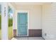 Welcome home! A light teal front door with a brick foundation and white pillars at 5207 Georgette Trl, Cherryville, NC 28021