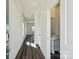 Bright hallway with wood floors and a glimpse into the half bathroom, featuring modern fixtures at 5207 Georgette Trl, Cherryville, NC 28021