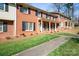 Exterior view of brick townhomes with dark shutters, green lawn and walkway at 623 S New Hope Rd # 4, Gastonia, NC 28054